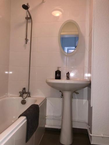 une salle de bain avec un lavabo, un miroir et une baignoire dans l'établissement Chez Jeanne - 2 personnes, à Colmar