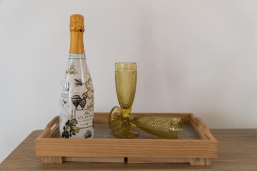 Cabaña de Nemiña (A casa de Anxo e Samu) في موتشيا: صينية خشبية عليها زجاجة وأشياء أخرى