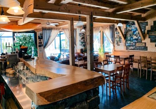Hostel Soča Rocks في بوفيك: بار في مطعم به طاولات وكراسي