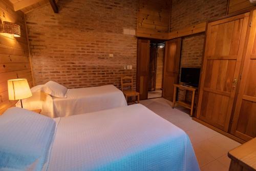 a hotel room with two beds and a television at Il Belvedere in Punta del Este