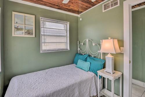 Un dormitorio con una cama en una habitación con paredes verdes. en Cozy Ormond Beach Bungalow Steps to the Sand, en Ormond Beach