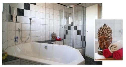 ein Bad mit einer großen weißen Badewanne in einem Zimmer in der Unterkunft FeWo Becka "das kleine Paradies" in Weiskirchen