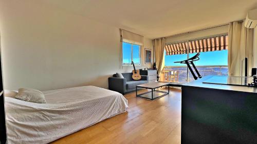 a bedroom with a bed and a living room with a view at OLIVIERS DE FABRON in Nice