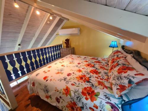 a bedroom with a bed with a floral comforter at Chrisanns Paradise Suite by the Ocean - Apt#9 in Ocho Rios