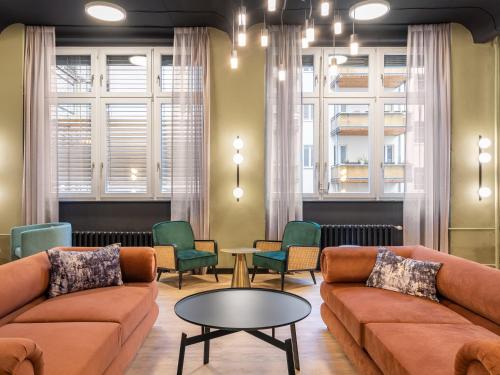 ein Wohnzimmer mit Sofas, einem Tisch und Stühlen in der Unterkunft numa l Sketch Rooms & Apartments in Berlin
