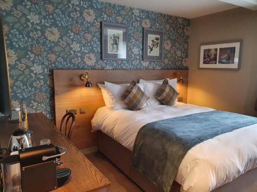 um quarto de hotel com uma cama e uma mesa em Old Swan em Skipton