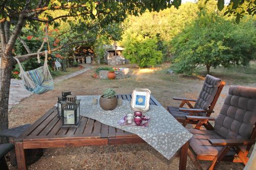 a wooden table with a clock on it next to two chairs at Koromilia Villa in Neo Klima