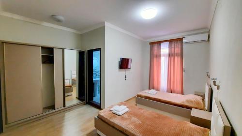 HOTEL KOSHKI في زوغديدي: غرفة نوم بسريرين ومرآة كبيرة