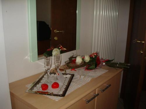 a bathroom counter with glasses and flowers on it at Agritur Ca' Scudiera in Belluno Veronese