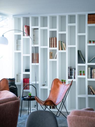 a living room with chairs and bookshelves at A House in Estoril - Adults Only in Estoril