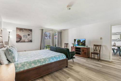 a bedroom with a bed and a desk and a television at Ground Floor Cozy Condo Seconds from the Beach with Private Terrace in South Padre Island