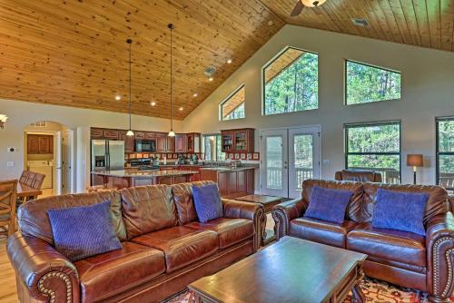 a living room with leather couches and a table at Serene Lakeside Cabin with Decks and Edler Lake Views! in Pinetop-Lakeside