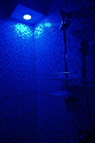 a bathroom with a shower with a blue light at Jonio B&B in Acireale