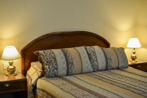 a bedroom with a bed with two lamps on tables at Hotel Centro Naval in Buenos Aires