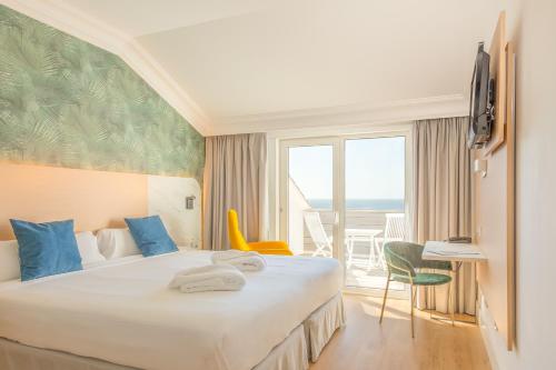 a hotel room with a bed with a view of the ocean at Talaso Atlántico in Mougás