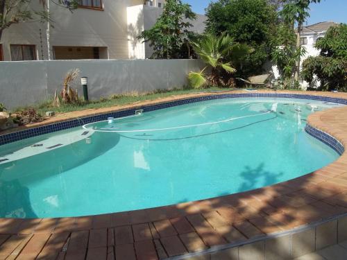 a large swimming pool with blue water in a yard at Carlcyn Homestay in Gaborone