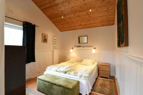 um quarto com uma cama e um tecto de madeira em Cozy cottage in Arjang near the lake and untouched nature em Arjäng