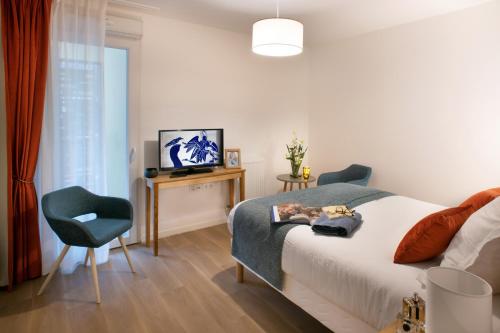 - une chambre avec un lit, une chaise et une télévision dans l'établissement Résidence Services DOMITYS La Cantate, à Dunkerque
