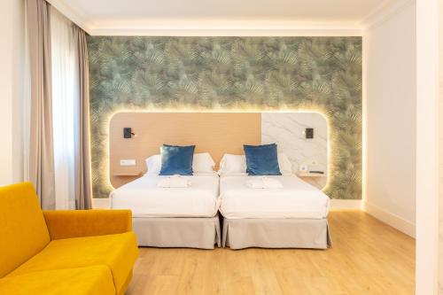 a hotel room with two beds and a couch at Talaso Atlántico in Mougás