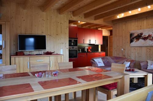 a living room with a table and a kitchen at Ferienhaus Nr 2C plus, Feriendorf Hagbügerl, Bayr Wald in Waldmünchen