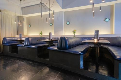 a restaurant with leather seats and tables and lights at Prodeo Hotel + Lounge in Buenos Aires