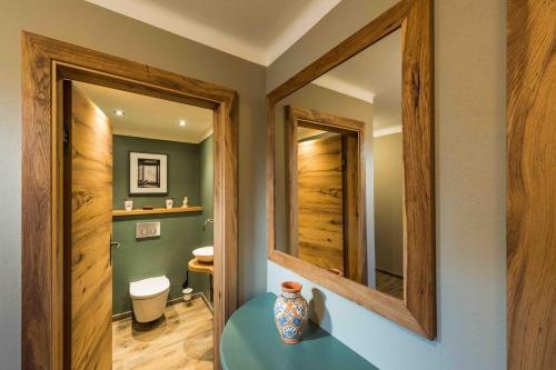 a bathroom with two mirrors and a vase on a table at Kitz-Chalet in Kitzbühel