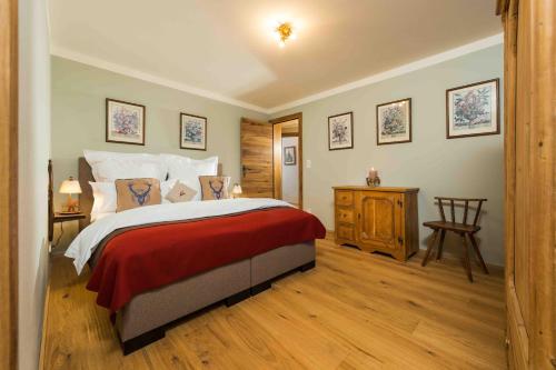 基茨比厄爾的住宿－Kitz-Chalet，一间卧室设有一张大床,铺有木地板
