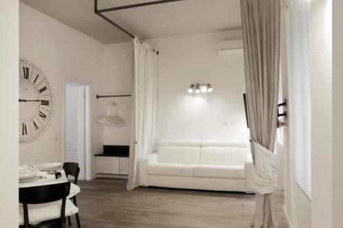 sala de estar blanca con sofá blanco y reloj en Trastevere Residence, en Roma