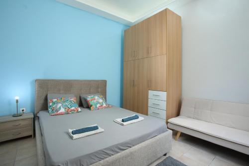 1 dormitorio con 1 cama, 1 silla y 1 armario en Nikea apartment near Piraeus port and metro st I, en Pireo