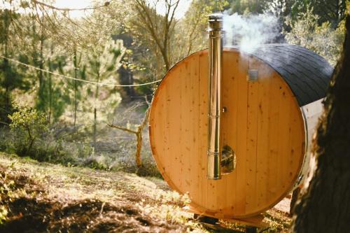a wooden barrel with a water fountain in the woods at The Lemon Lodge in Aljezur