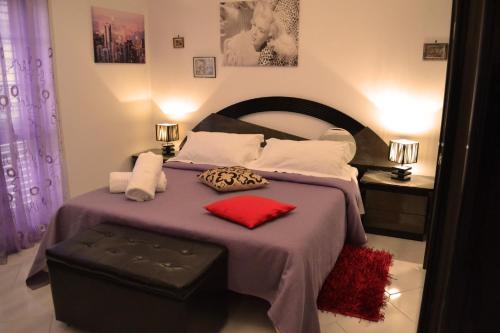 a bedroom with a large bed with a purple blanket at Villa Ambra B&B in Noto