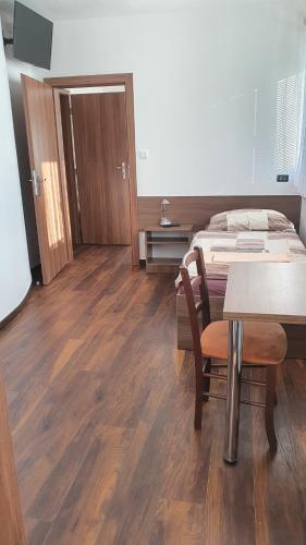 a room with a bed and a table and a table and chairs at Motorest U Kola in Prostějov