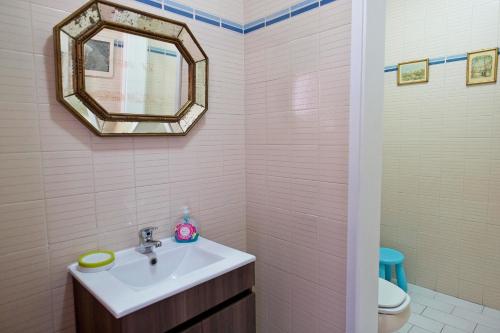 een badkamer met een wastafel, een spiegel en een toilet bij SeetheSea in Nazaré
