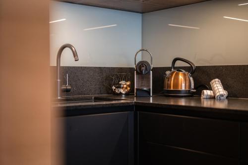 a kitchen with black cabinets and a tea kettle on the counter at Kleiner Alpiner Boudoir in der Residenz Silvretta - Inklusive Silvretta Card Premium in See