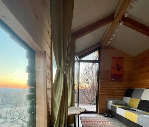 a room with a large window and a bed in a room at Langaland Glamping in Susenii Bîrgăului
