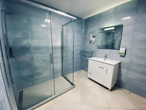 Un baño con ducha de cristal y lavabo. en ApartHotel NhaTerra, en Santa Maria