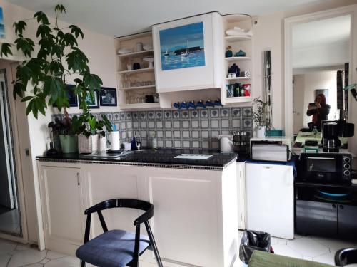 cocina con armarios blancos y encimera negra en Appartement de charme sur le Port de Marseillan en Marseillan