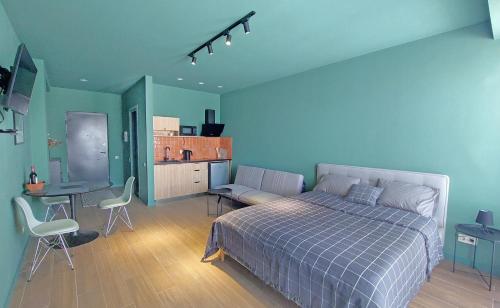 a bedroom with a bed and a desk and a kitchen at Gudauri Roshka Studio Apt #412 in Gudauri