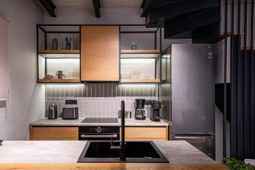 una cucina con lavandino e piano cottura forno superiore di Chania Residence - City centre maisonette a Chania