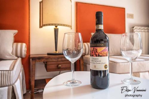 a bottle of wine sitting on a table with two wine glasses at Casa Il Melograno in San Miniato