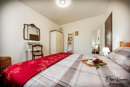 a bedroom with a bed with a tray of flowers on it at Casa Il Melograno in San Miniato
