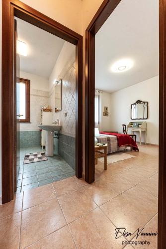 a room with a bathroom with a sink and a bed at Casa Il Melograno in San Miniato