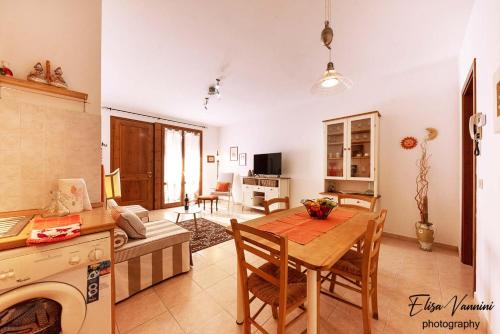 a kitchen and living room with a table and a couch at Casa Il Melograno in San Miniato