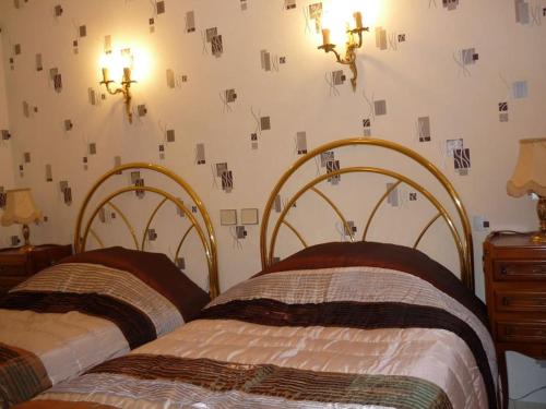 - 2 lits dans une chambre dotée d'un mur avec des photos dans l'établissement Coquet appartement en Périgord, à Pechpialat