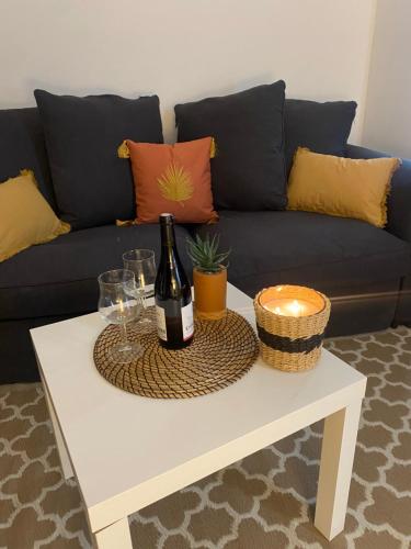 - une bouteille de vin sur une table basse devant un canapé dans l'établissement Paradis les pieds sur le sable trouville palace, à Trouville-sur-Mer