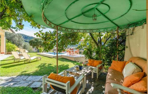 patio ze stołem i zielonym parasolem w obiekcie Villa Lavandaia Toscana w mieście Stiava