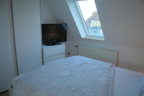a bedroom with a bed and a flat screen tv at FischLANDinSicht in Ribnitz-Damgarten