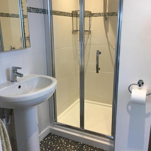a bathroom with a shower and a sink at Kerryanna Country House Bed and Breakfast in Mevagissey