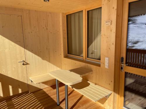 a wooden cabin with a bench in front of a window at Wasserfall Apartments Mellau in Mellau
