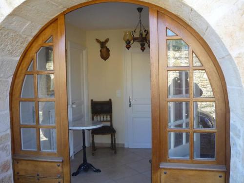 una entrada arqueada con una puerta de madera y una mesa en Studio 2 personnes, en Pechpialat